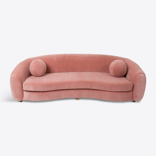 curved sofa in pink velvet with pink ball cushions