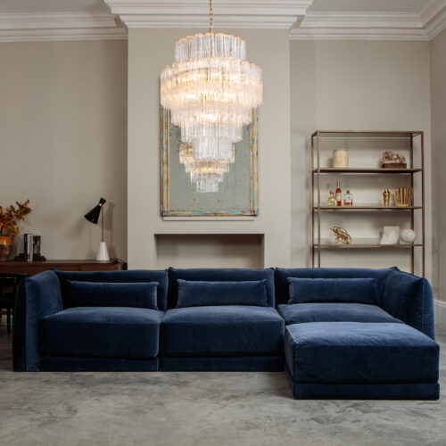 Milano cornflower blue sectional sofa with mid-century inspired clear glass chandelier