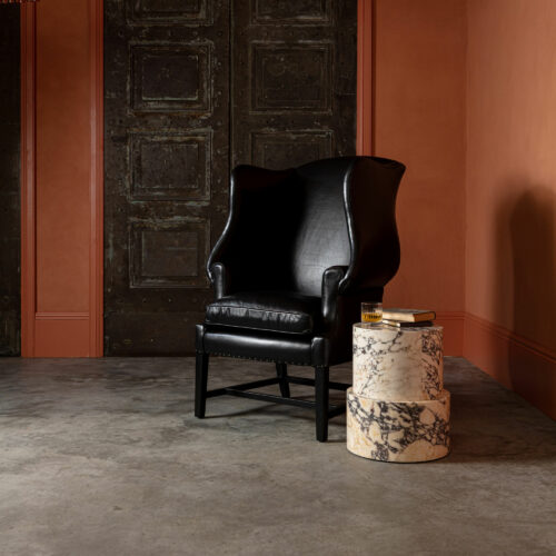 Panama Viola marble side table round plinth and black leather wingback armchair